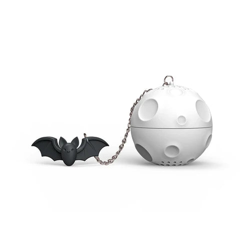Black bat-shaped tea infuser and white spherical tea ball on a white background