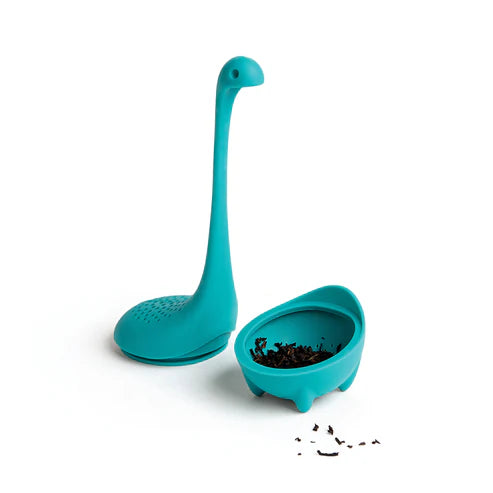 Teal dinosaur-shaped tea infuser with a small bowl on a white background